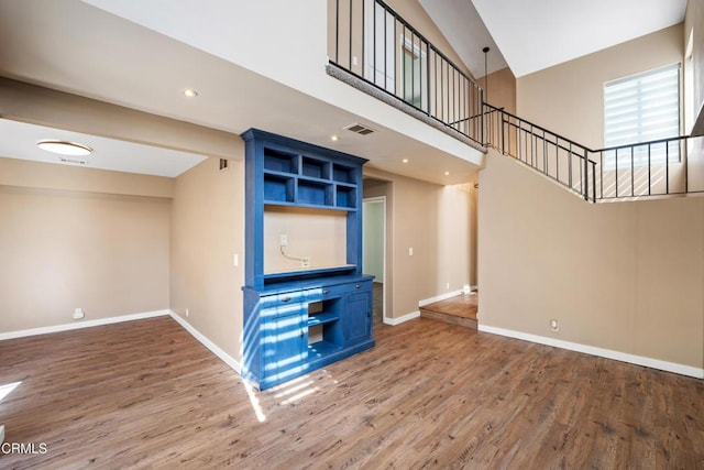 unfurnished living room featuring hardwood / wood-style flooring and lofted ceiling