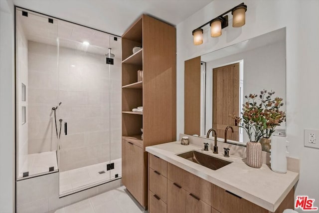 bathroom featuring tile patterned flooring, vanity, and walk in shower