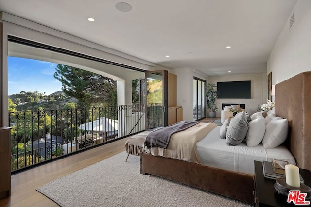 bedroom with light hardwood / wood-style floors and access to exterior