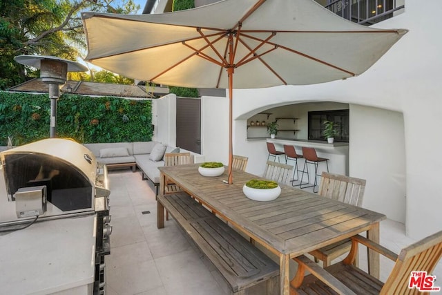 view of patio featuring exterior bar, an outdoor kitchen, and grilling area