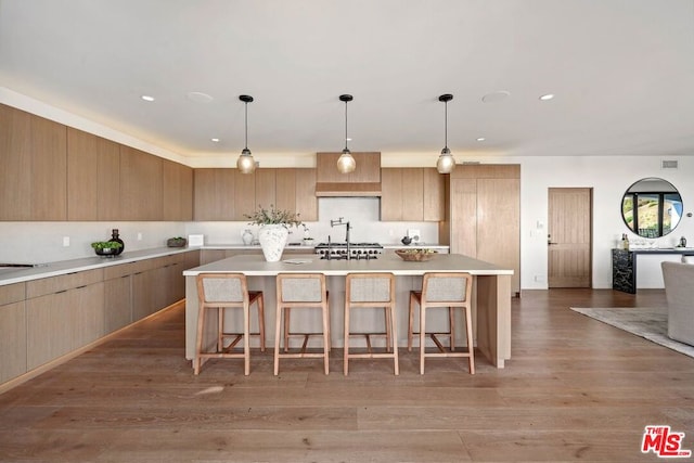 kitchen with dark hardwood / wood-style flooring, a kitchen island, and hanging light fixtures