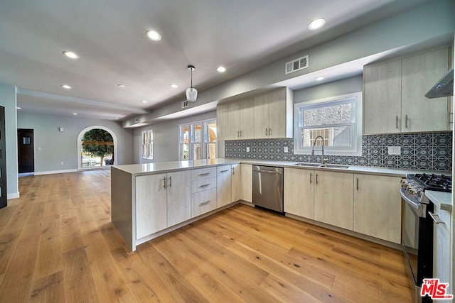 kitchen featuring light hardwood / wood-style flooring, stainless steel appliances, kitchen peninsula, and sink