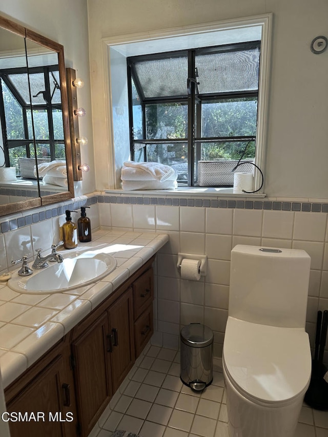 bathroom featuring tile patterned flooring, plenty of natural light, vanity, and toilet