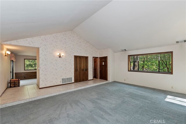 empty room with light carpet and lofted ceiling