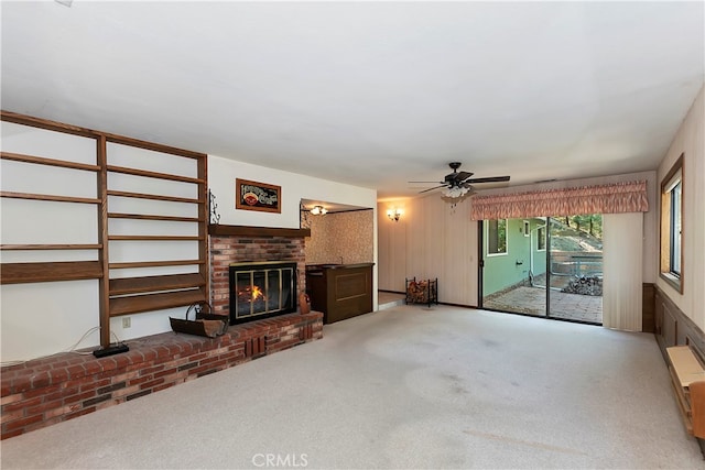 living room with carpet floors, a brick fireplace, and ceiling fan