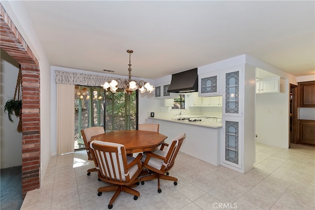 tiled dining space featuring a notable chandelier