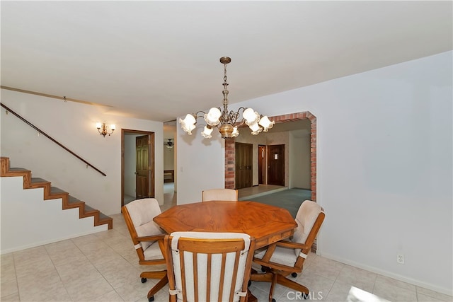 tiled dining room with a chandelier