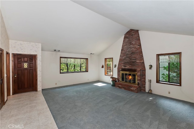 unfurnished living room featuring vaulted ceiling, light colored carpet, and a brick fireplace