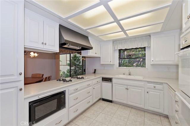 kitchen with white appliances, white cabinets, extractor fan, and plenty of natural light