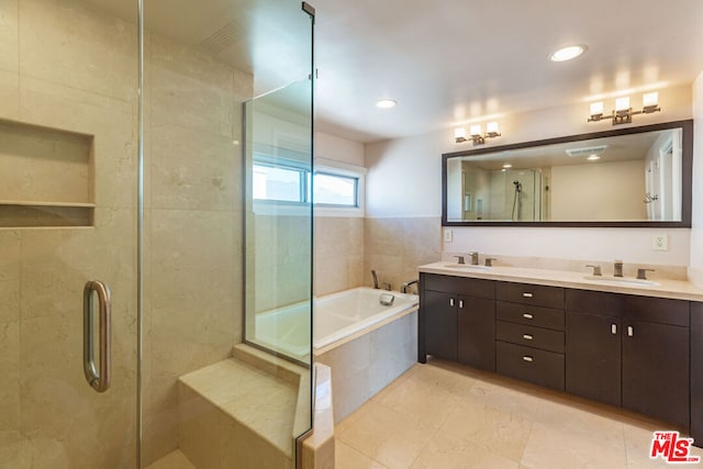 bathroom with vanity and shower with separate bathtub