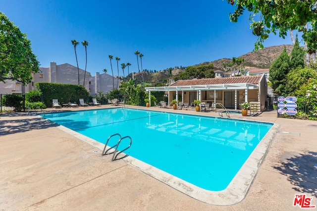 view of pool with a mountain view and a patio area