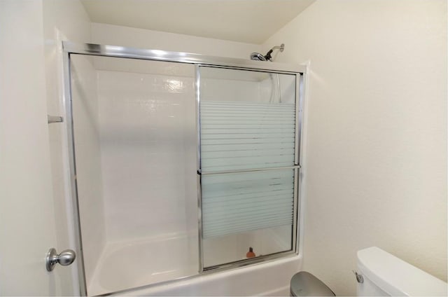 bathroom with shower / bath combination with glass door and toilet