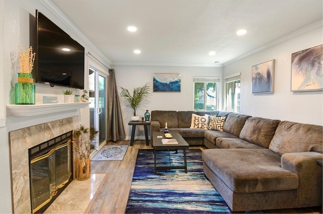 living room featuring hardwood / wood-style flooring, ornamental molding, and a tile fireplace