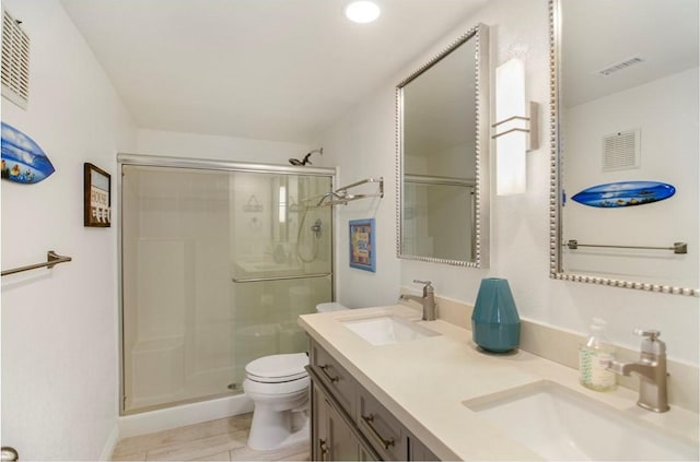 bathroom featuring tile patterned flooring, vanity, toilet, and an enclosed shower