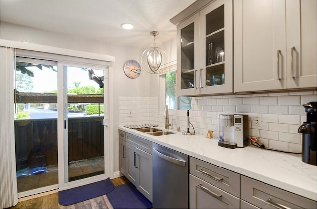 kitchen with dishwasher, hanging light fixtures, dark hardwood / wood-style floors, gray cabinets, and light stone counters