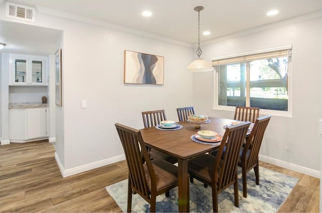 dining space featuring hardwood / wood-style flooring and crown molding