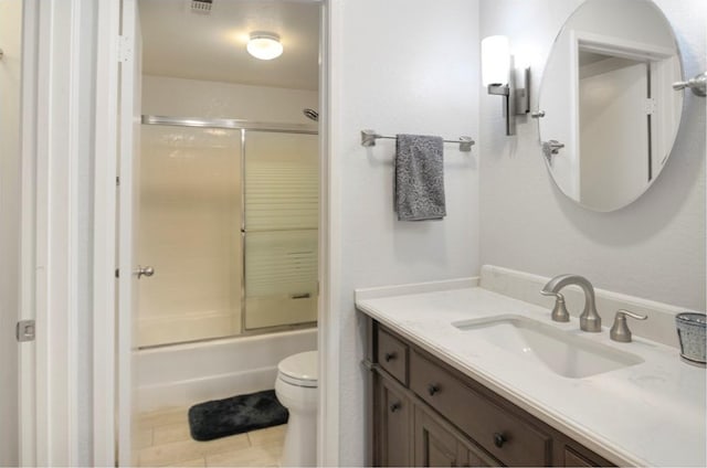 full bathroom with shower / bath combination with glass door, tile patterned floors, vanity, and toilet