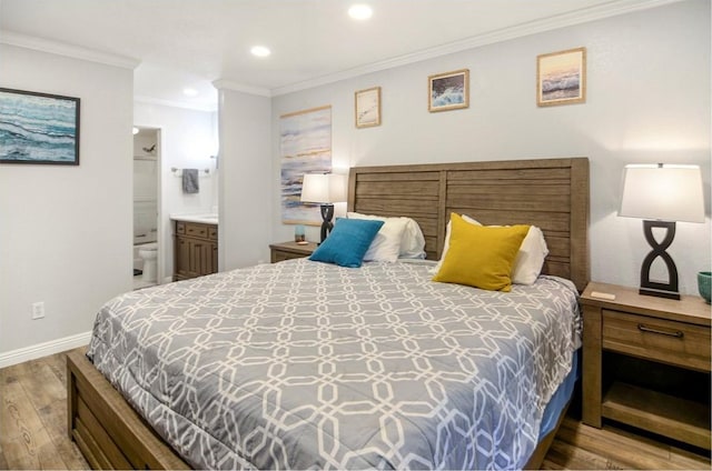 bedroom featuring light wood-type flooring, ensuite bathroom, and ornamental molding