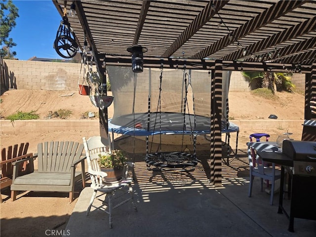 view of patio with area for grilling, a pergola, and a trampoline