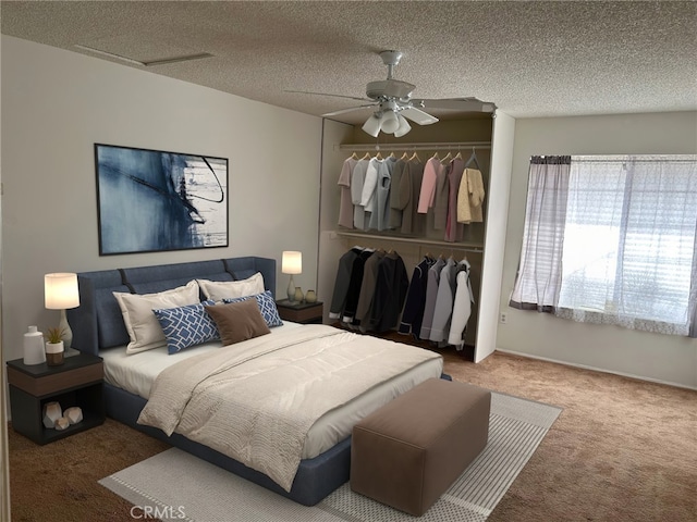 bedroom with ceiling fan, carpet floors, a closet, and a textured ceiling