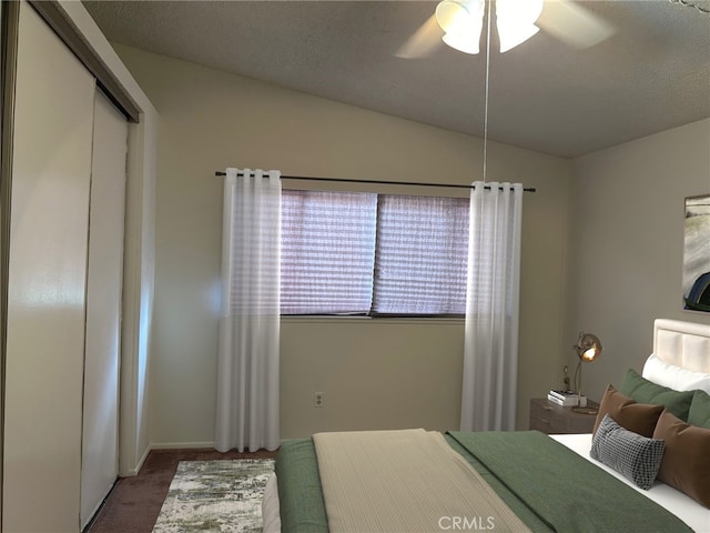 bedroom with vaulted ceiling, a closet, ceiling fan, and carpet