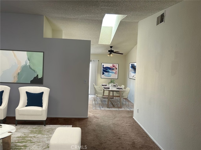 interior space featuring ceiling fan, vaulted ceiling, and a textured ceiling