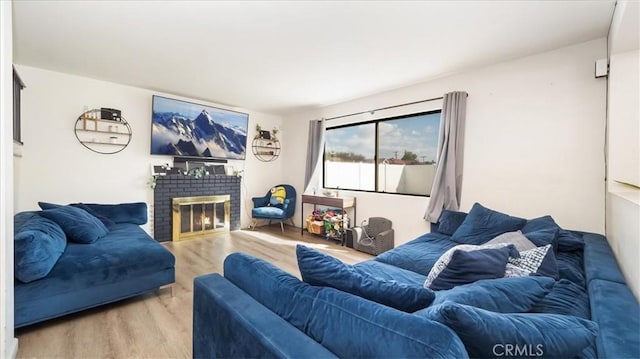 living room with a brick fireplace and light hardwood / wood-style flooring