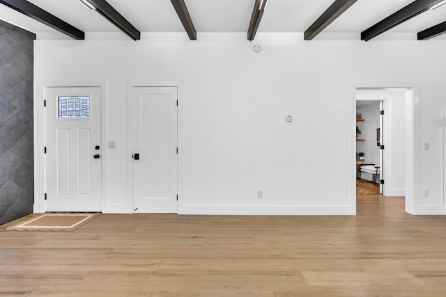 entryway with beam ceiling and light hardwood / wood-style flooring