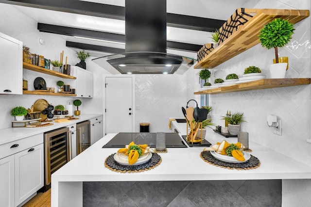 kitchen featuring wine cooler, decorative backsplash, island range hood, and white cabinetry