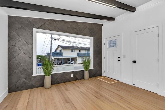 entrance foyer featuring wood-type flooring and beamed ceiling