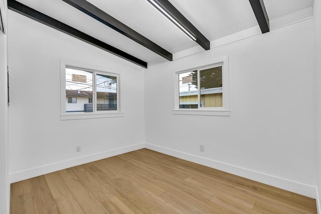 unfurnished room featuring lofted ceiling with beams and light wood-type flooring