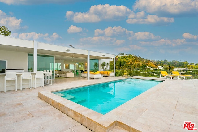 view of swimming pool with a patio and an outdoor living space