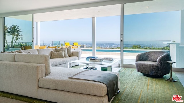 living room with expansive windows, a water view, and a wealth of natural light