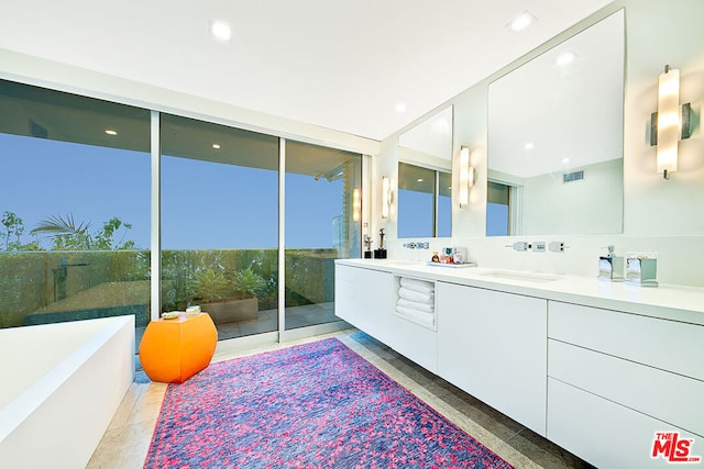 bathroom featuring vanity, floor to ceiling windows, and a tub