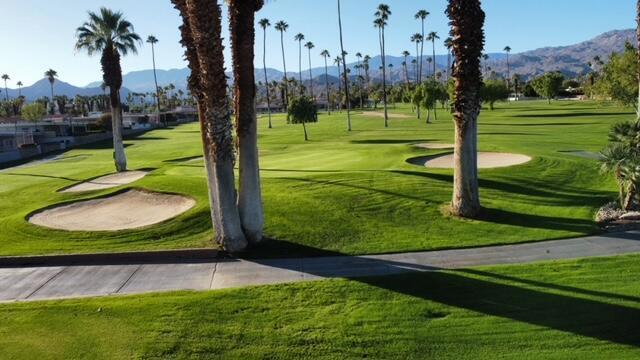 surrounding community with a mountain view and a lawn