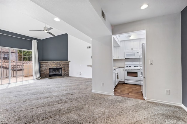 unfurnished living room featuring a fireplace, carpet, and ceiling fan