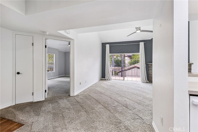 empty room featuring light carpet, plenty of natural light, and ceiling fan