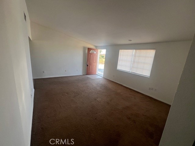 unfurnished room featuring dark colored carpet