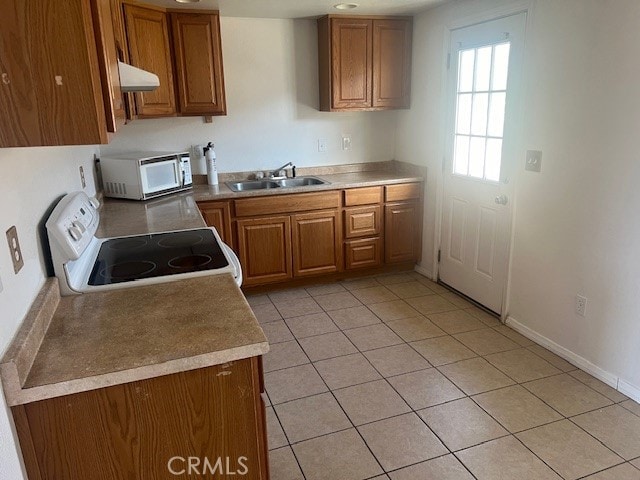 kitchen featuring white appliances, light tile patterned flooring, and sink