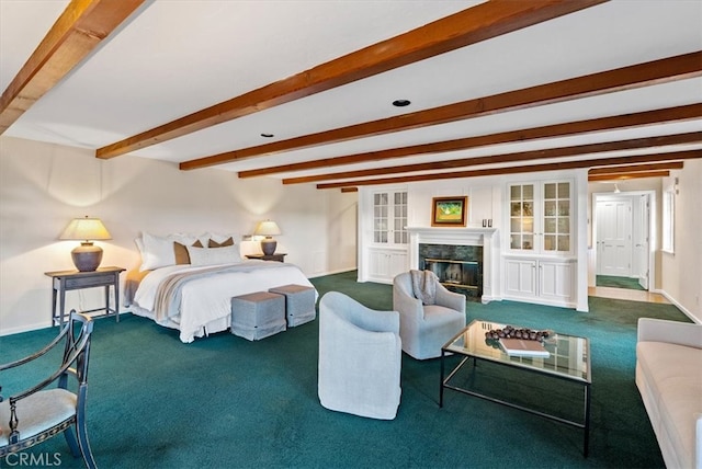 bedroom with beam ceiling, dark carpet, and a fireplace