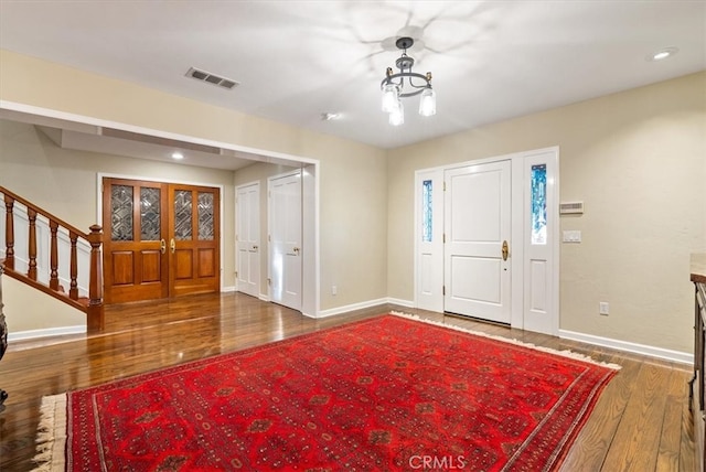 entryway with a chandelier and dark hardwood / wood-style floors