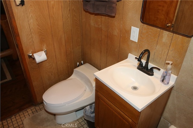 bathroom featuring wooden walls, vanity, and toilet