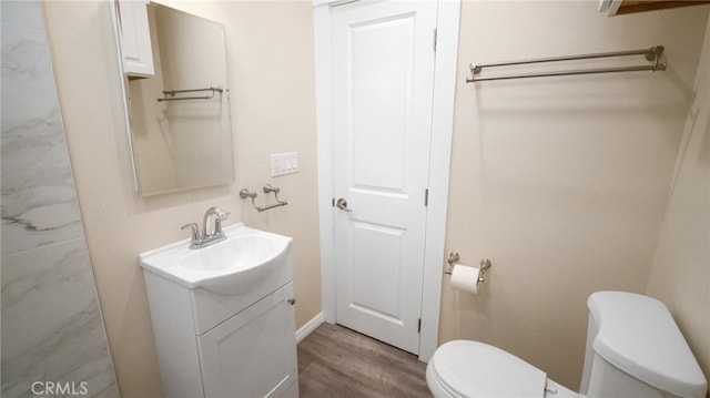 bathroom with hardwood / wood-style flooring, vanity, and toilet