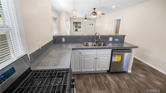 kitchen featuring sink, decorative light fixtures, white cabinetry, appliances with stainless steel finishes, and dark hardwood / wood-style flooring