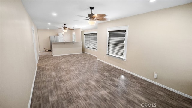 unfurnished living room with ceiling fan and dark hardwood / wood-style flooring