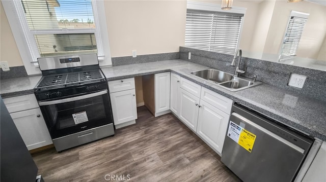 kitchen featuring appliances with stainless steel finishes, white cabinetry, dark hardwood / wood-style floors, and sink