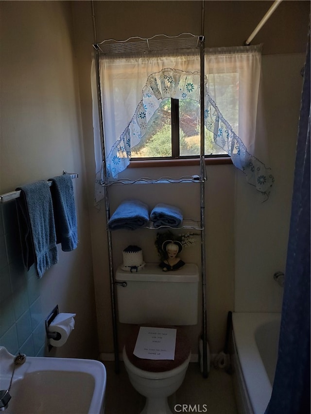 full bathroom with sink, shower / tub combo, and toilet