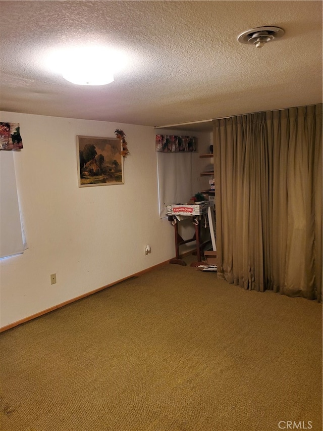 basement with a textured ceiling and carpet flooring