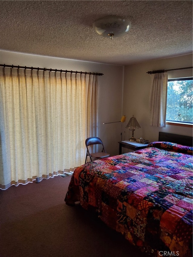 bedroom with a textured ceiling and carpet floors