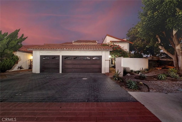 mediterranean / spanish home featuring a garage